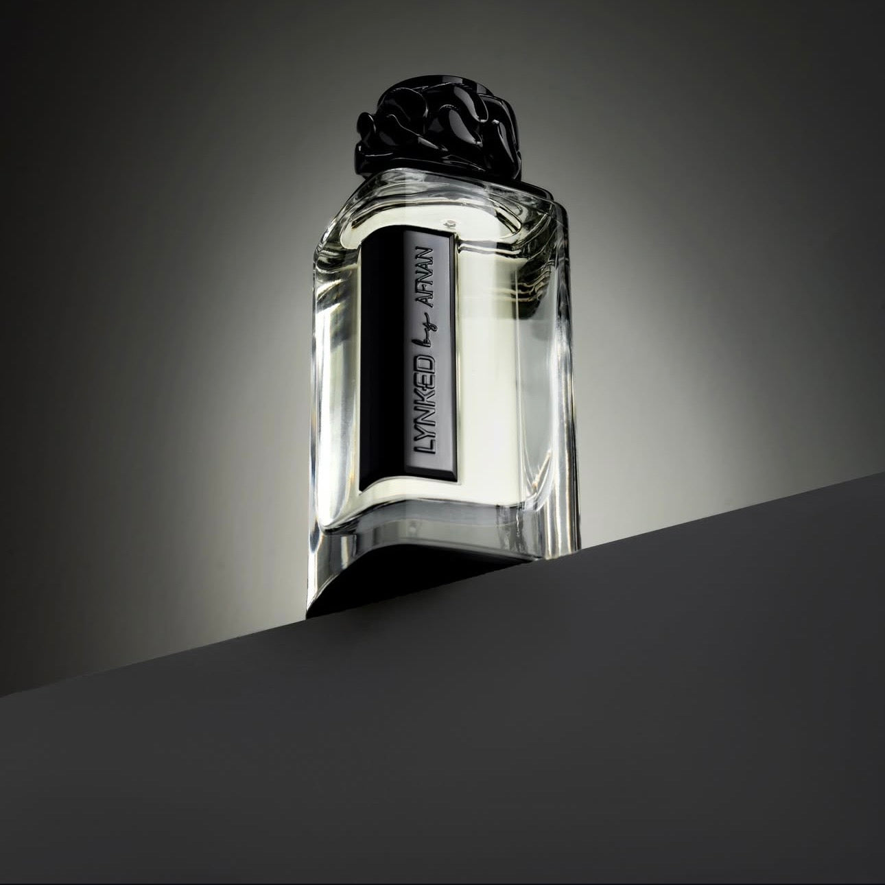 Perfume bottle with black rose design on a gray background